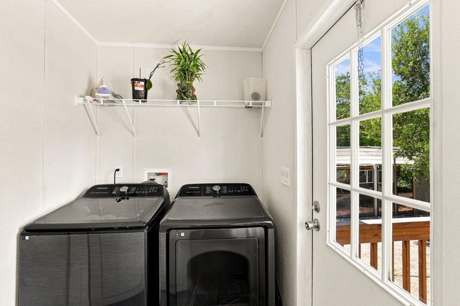 Functional workspace includes laundry connections and a glass-paned door opening to the outdoors.