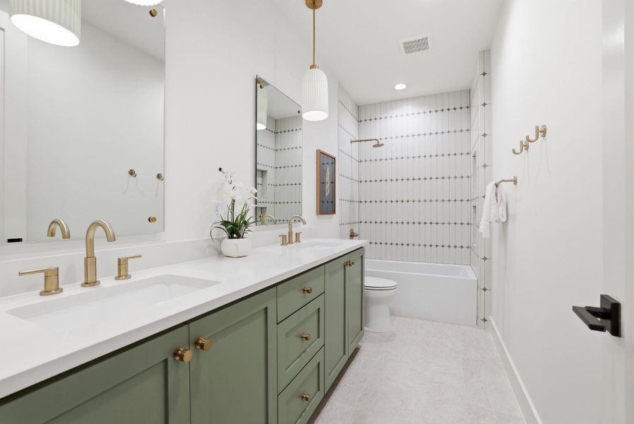 Bathroom featuring bathing tub / shower combination and double vanity