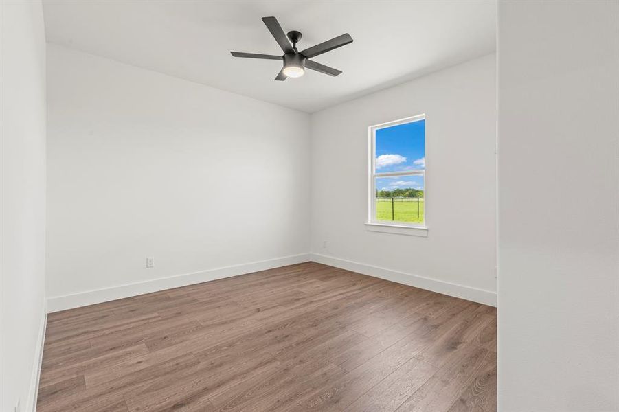 Empty room featuring wood finished floors and a ceiling fan