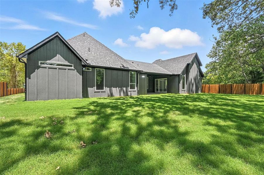 Back of house with board and batten siding and roof with shingles Back of house with board and batten siding and roof with shingles