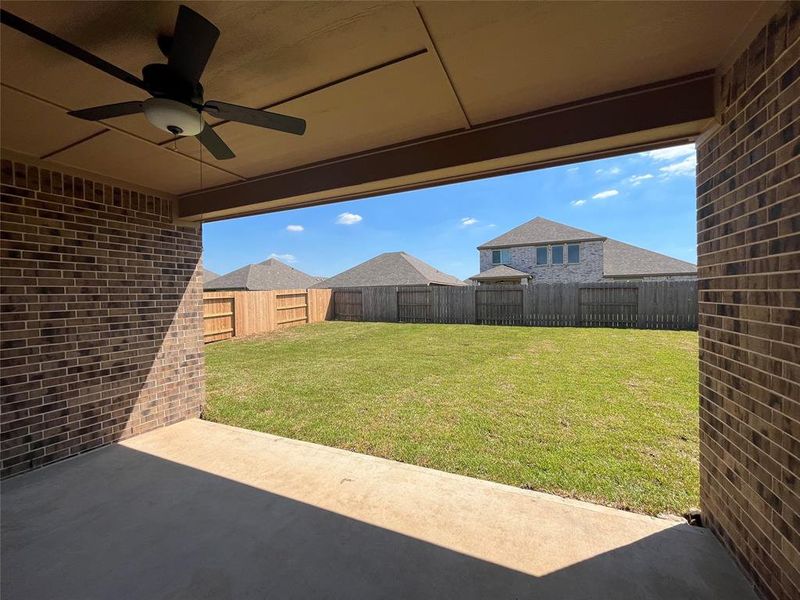 The cover patio includes stylish ceiling fan and overlooks the backyard