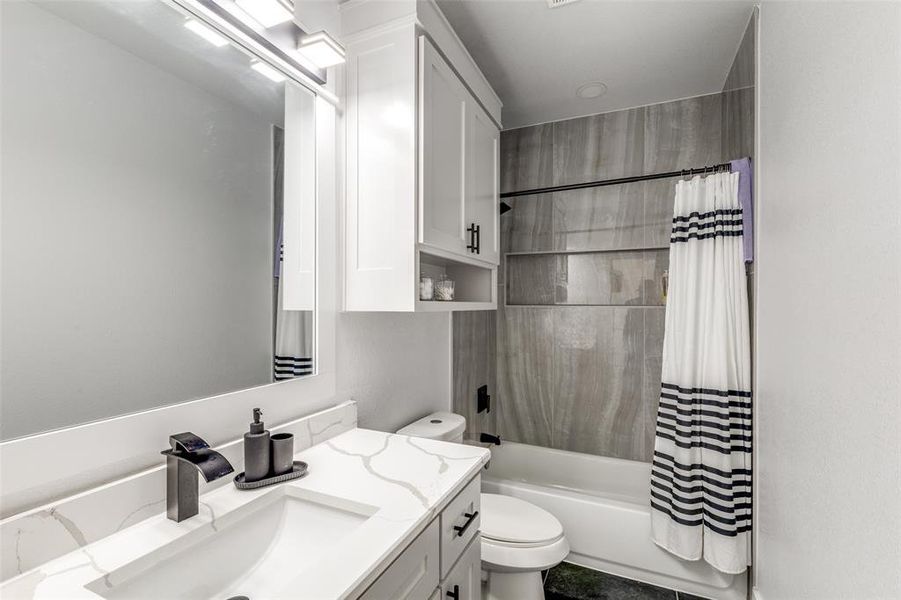 Full bathroom with toilet, shower / tub combo, and vanity