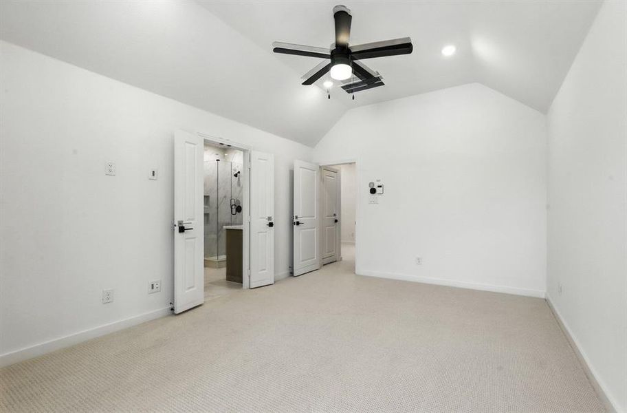 Unfurnished bedroom featuring carpet flooring, lofted ceiling, ceiling fan, and ensuite bath Unfurnished bedroom featuring carpet flooring, lofted ceiling, ceiling fan, and ensuite bath
