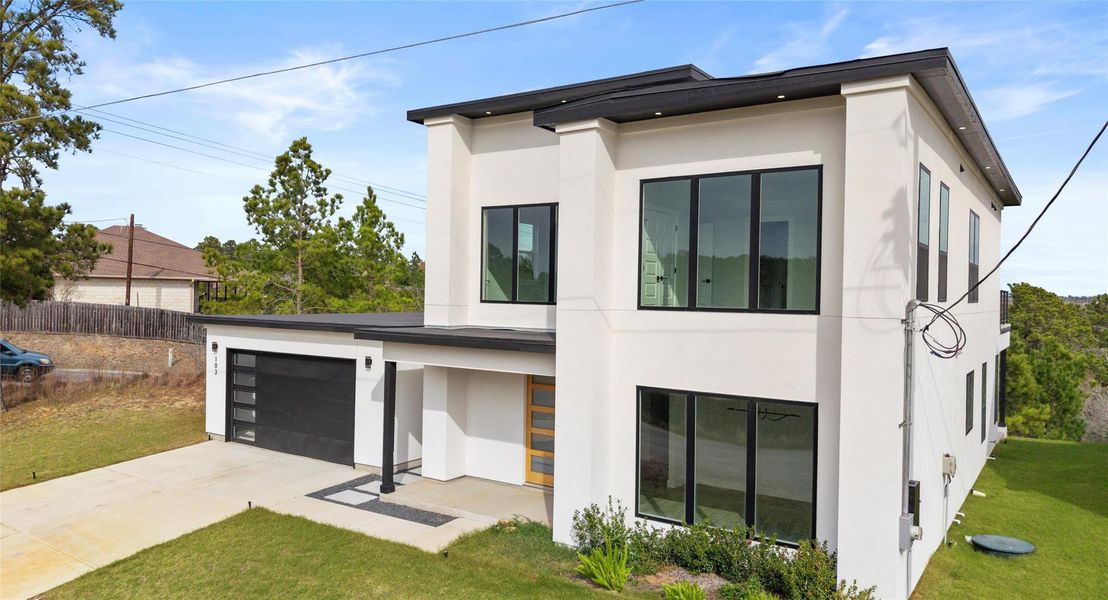 View of front facade with stucco siding and driveway