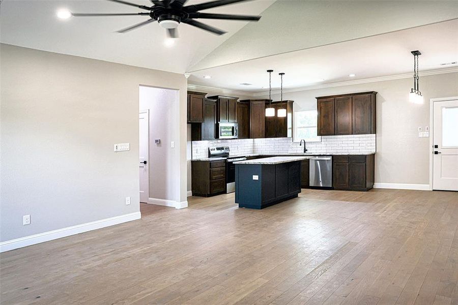 Kitchen with stainless steel appliances, granite countertops and decorative and under cabinet lighting.