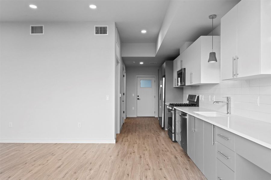 Kitchen with visible vents, backsplash, stainless steel appliances, and a sink