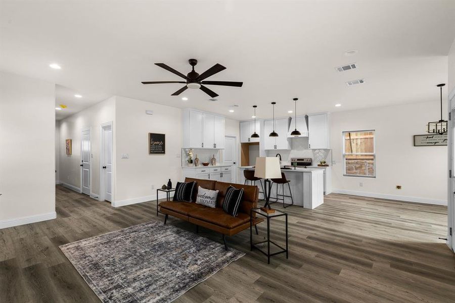 Living room featuring dark wood-type flooring and ceiling fan