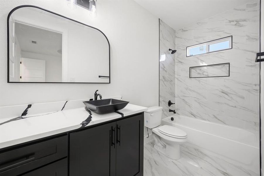 Modern bathroom featuring a black vanity with a white countertop, vessel sink, and matte black fixtures Modern bathroom featuring a black vanity with a white countertop, vessel sink, and matte black fixtures