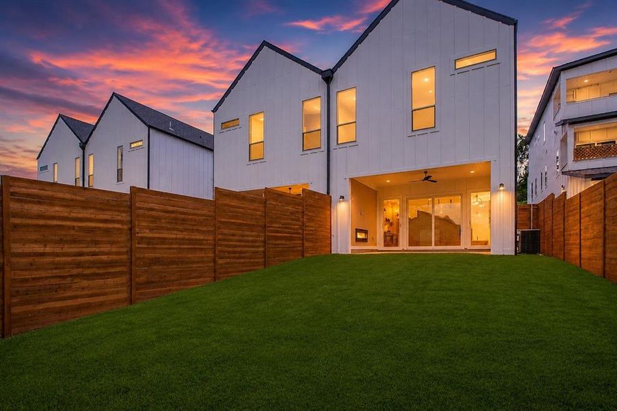 Expansive private backyard featuring a manicured lawn and horizontal plank fencing