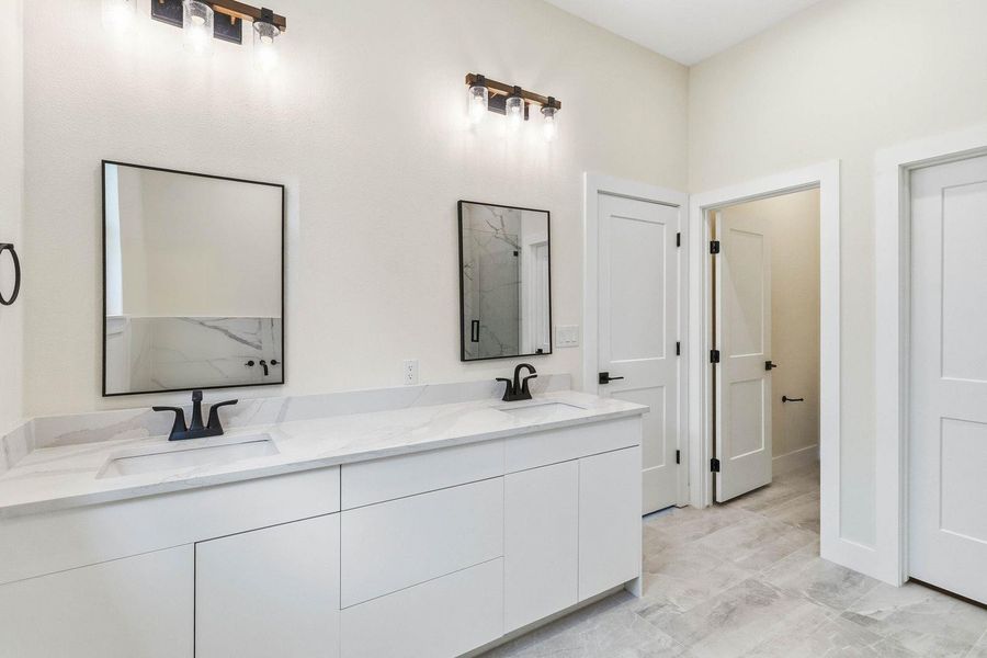 A well-appointed bathroom offers a double vanity with ample counter space and modern fixtures. A well-appointed bathroom offers a double vanity with ample counter space and modern fixtures.