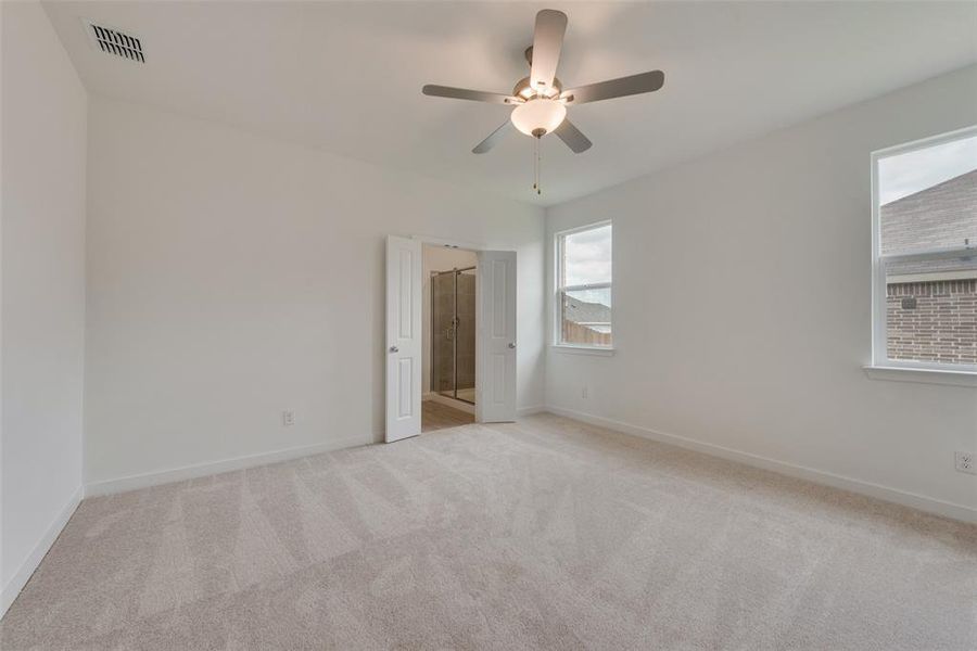 Carpeted empty room featuring ceiling fan