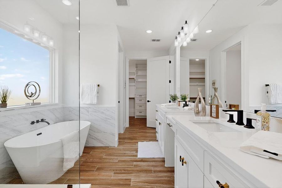 Bathroom featuring vanity, a freestanding bath, recessed lighting, tile walls, and a spacious closet