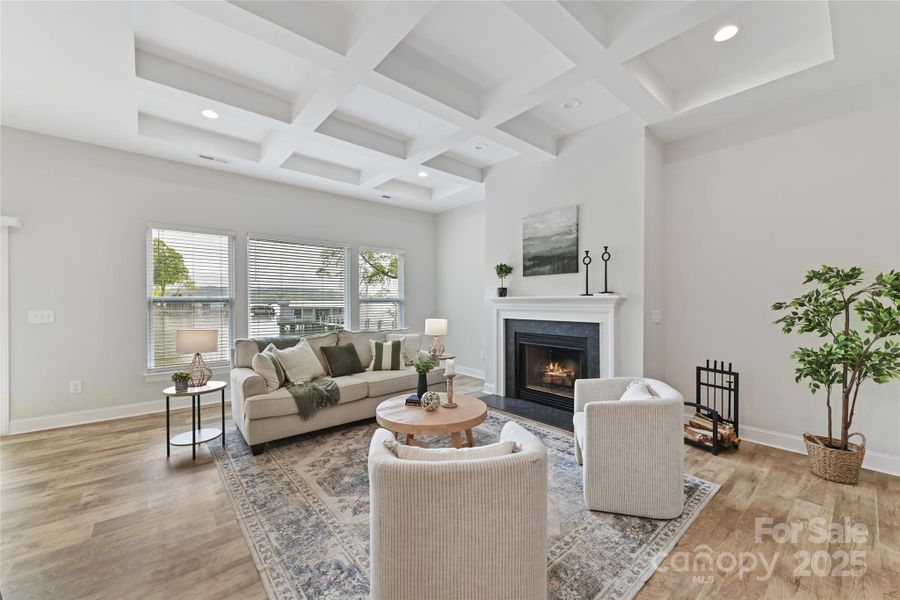 Great Room features wood burning fireplace, coffered ceiling, LVP floors & gorgeous lake views!