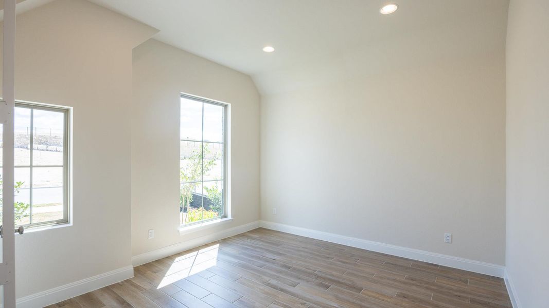 Empty room featuring recessed lighting, light wood-style floors, and lofted ceiling Empty room featuring recessed lighting, light wood-style floors, and lofted ceiling