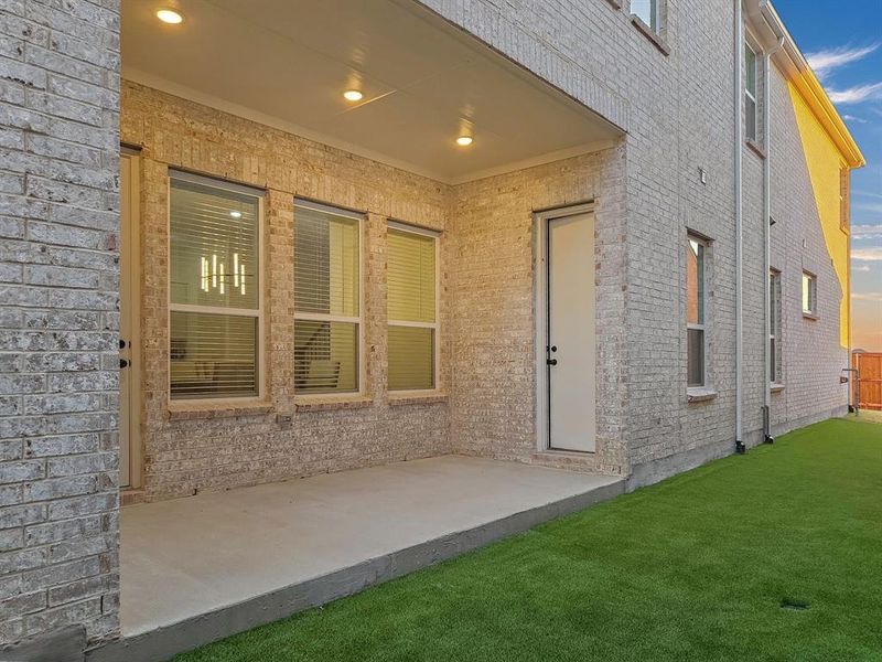 Exterior entry at dusk featuring a yard and a patio