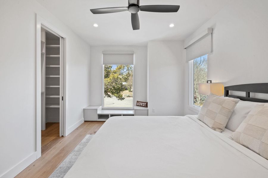 Bedroom featuring a spacious closet, light wood-style flooring, a ceiling fan, and recessed lighting