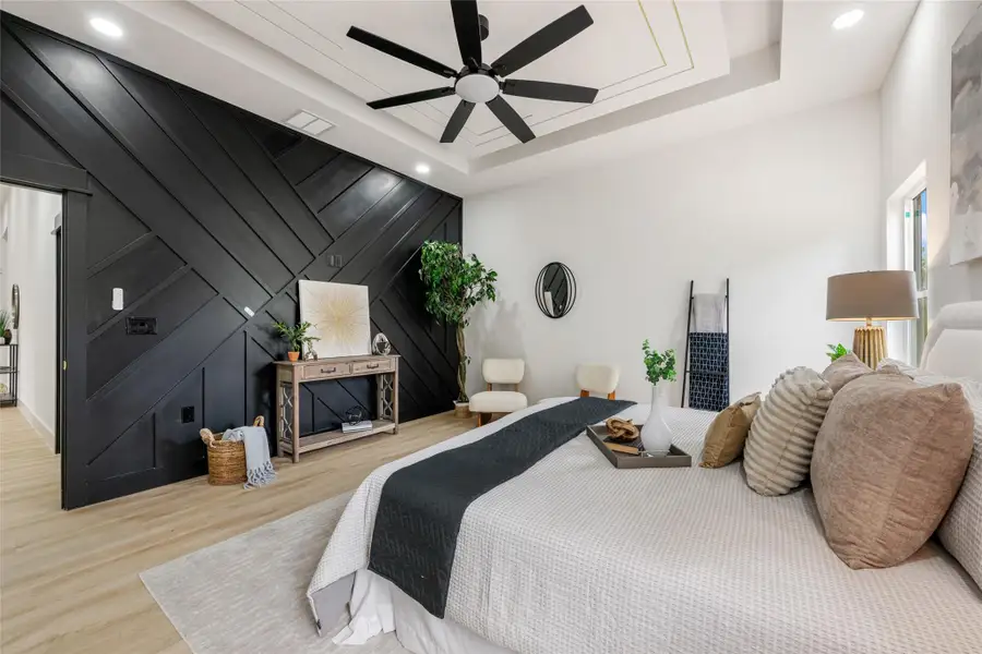Bedroom with wood finished floors, an accent wall, a decorative wall, recessed lighting, and a ceiling fan Bedroom with wood finished floors, an accent wall, a decorative wall, recessed lighting, and a ceiling fan