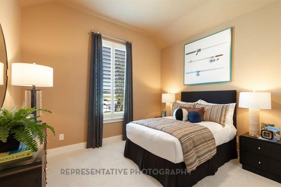 Carpeted bedroom featuring lofted ceiling and baseboards