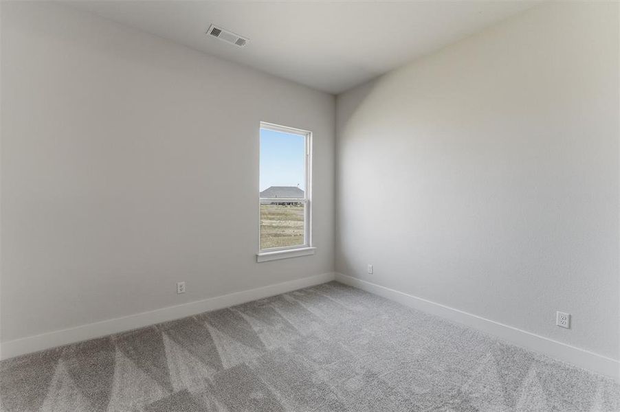 Spare room with light colored carpet and baseboards Spare room with light colored carpet and baseboards