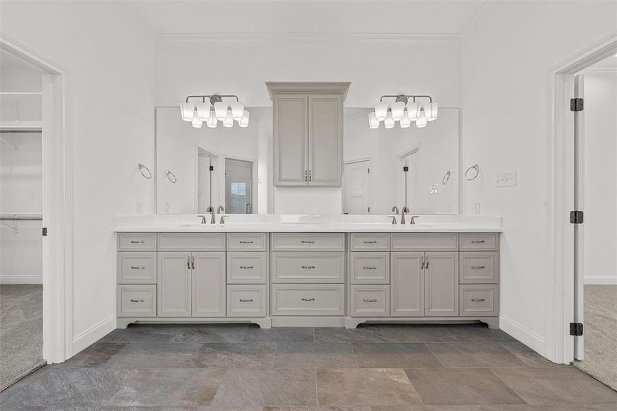 Bathroom with double vanity, crown molding, a walk in closet, and a chandelier Bathroom with double vanity, crown molding, a walk in closet, and a chandelier