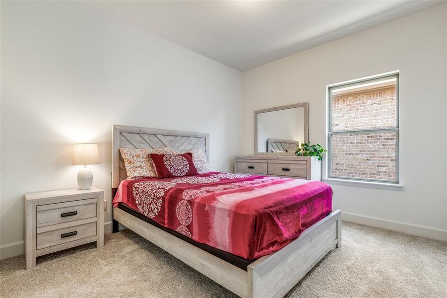 Bedroom featuring light carpet