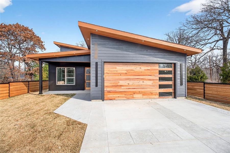Contemporary house featuring driveway and a garage Contemporary house featuring driveway and a garage