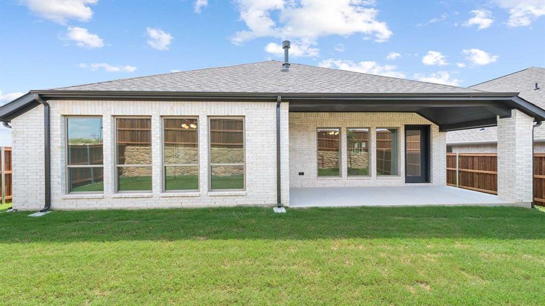 Rear view of house with a yard and a patio