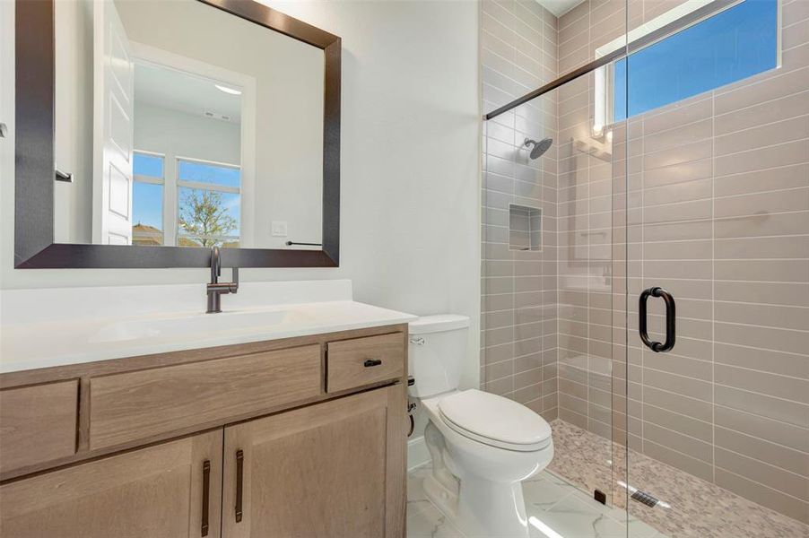 Bathroom featuring healthy amount of natural light, vanity, and a stall shower