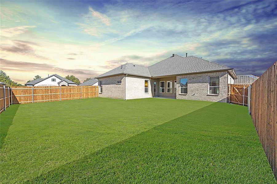 Fully fenced level backyard with sprinkler system and rain gutters.