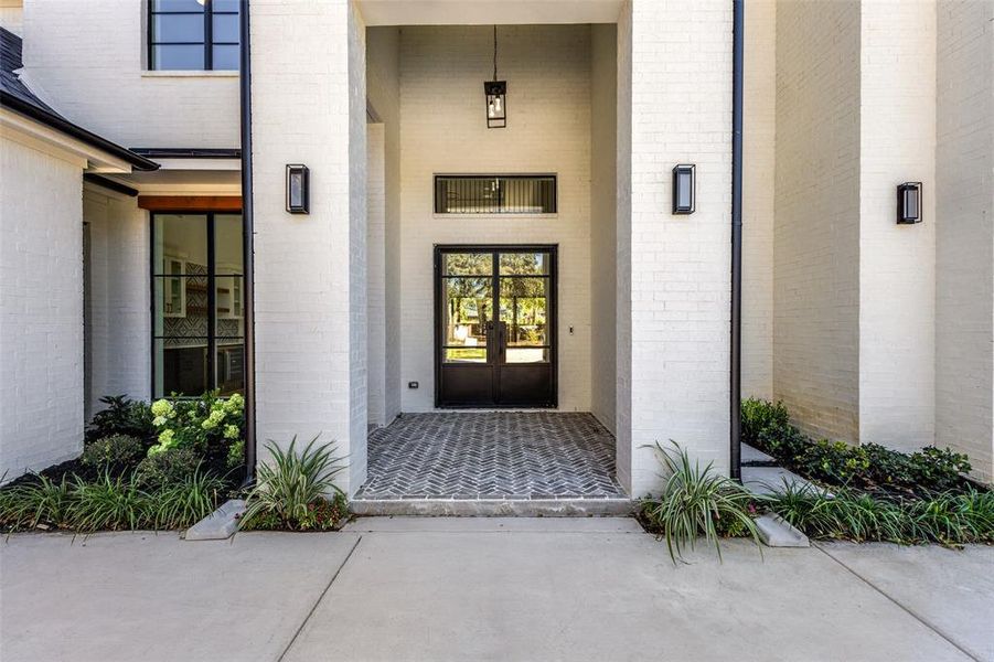 Doorway to property featuring brick siding and french doors Doorway to property featuring brick siding and french doors