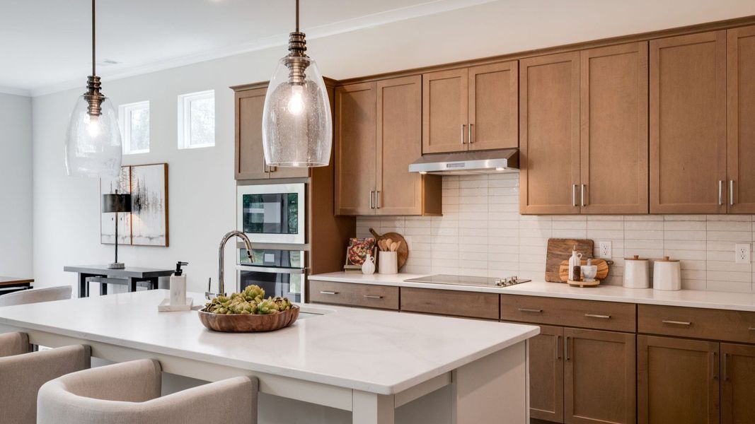 Hanging lights over kitchen island next to versatile living space Hanging lights over kitchen island next to versatile living space