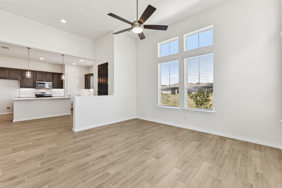 Unfurnished living room featuring light wood-style floors, recessed lighting, a ceiling fan, and a towering ceiling Unfurnished living room featuring light wood-style floors, recessed lighting, a ceiling fan, and a towering ceiling