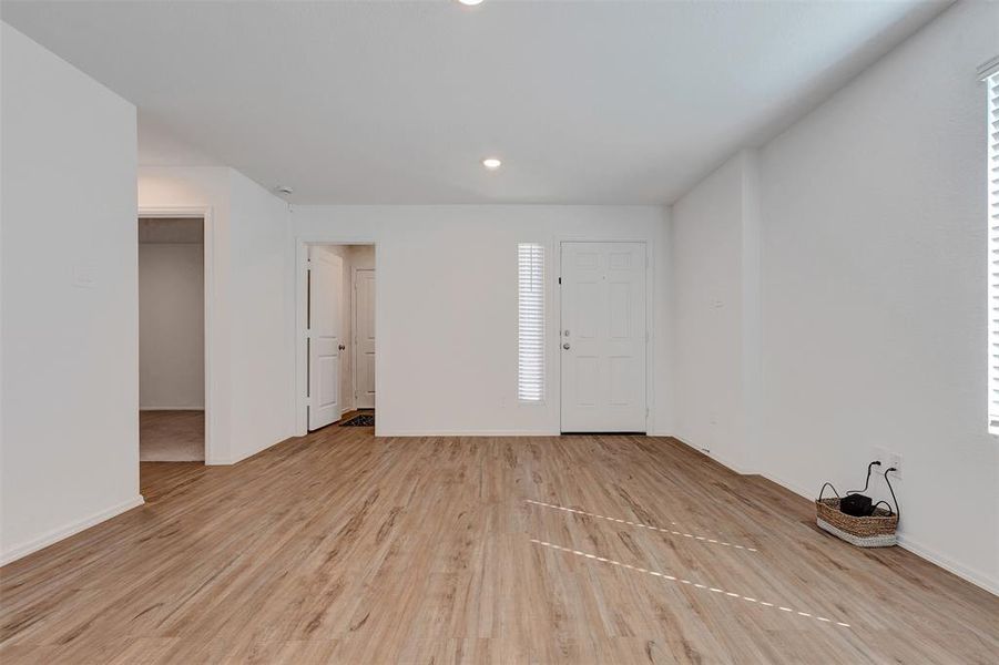 Another view of the family room towards front entrance.  Two secondary bedrooms to the left and laundry room opens to garage.