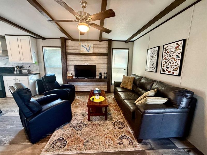 Living room with beam ceiling and a ceiling fan