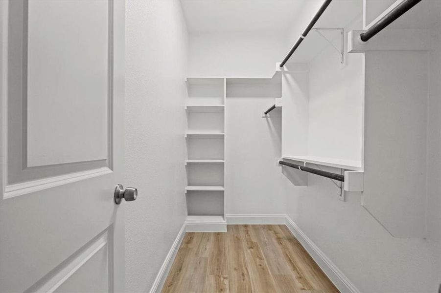 Spacious closet with light hardwood / wood-style floors