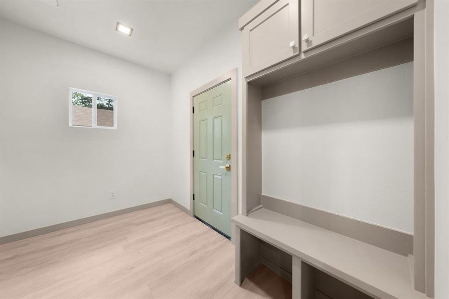 Mudroom featuring light wood-style floors and baseboards
