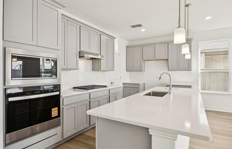 Island kitchen with built-in stainless steel appliances