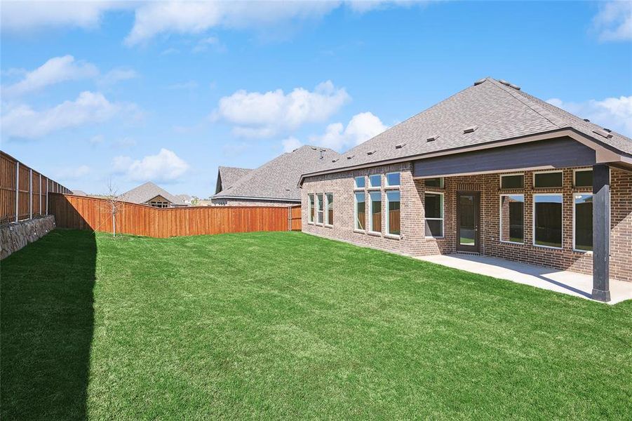 Back of property featuring a patio, brick siding, a fenced backyard, and a shingled roof