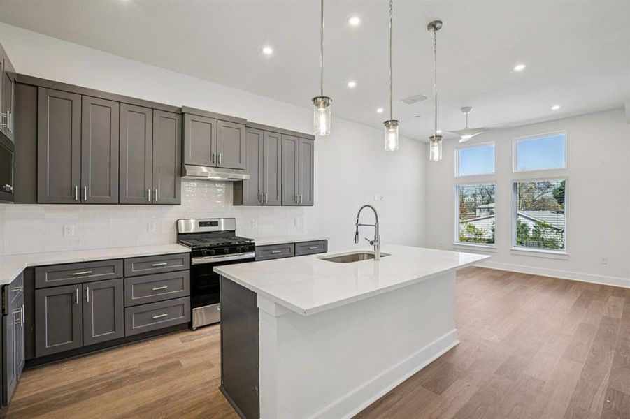 The kitchen is the heart of theliving space, featuring a largequartz island and stylish pendantlights hanging above. (Samplephoto of finishes and layout)