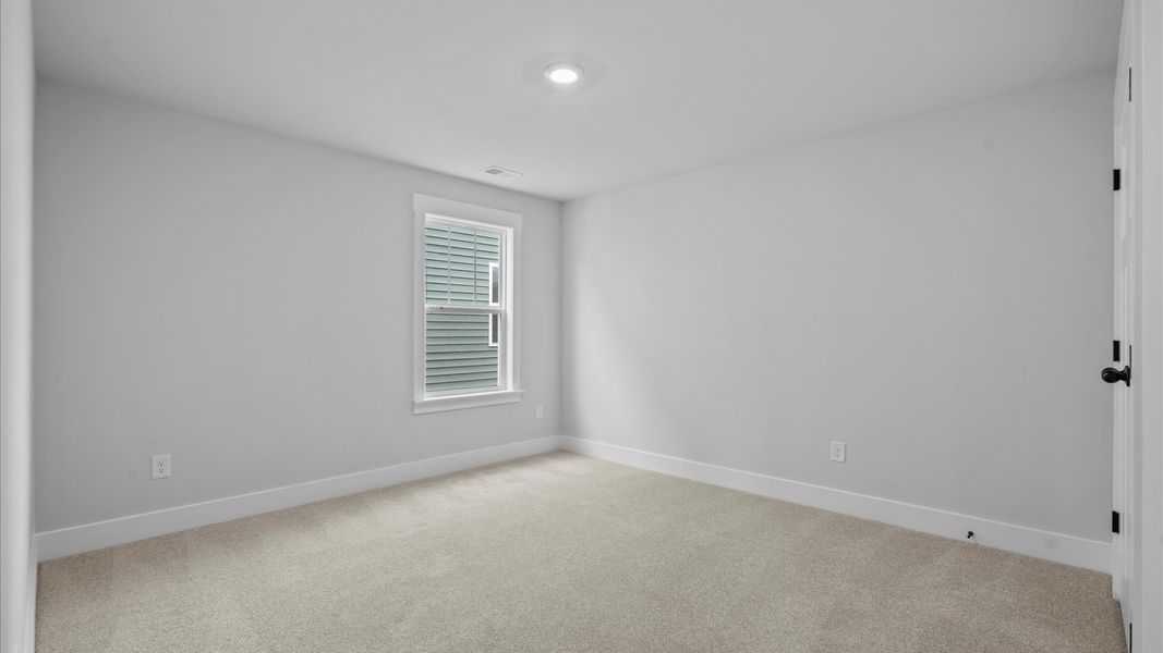First-rate secondary bedroom with a spacious walk-in closet and elegant carpeted flooring