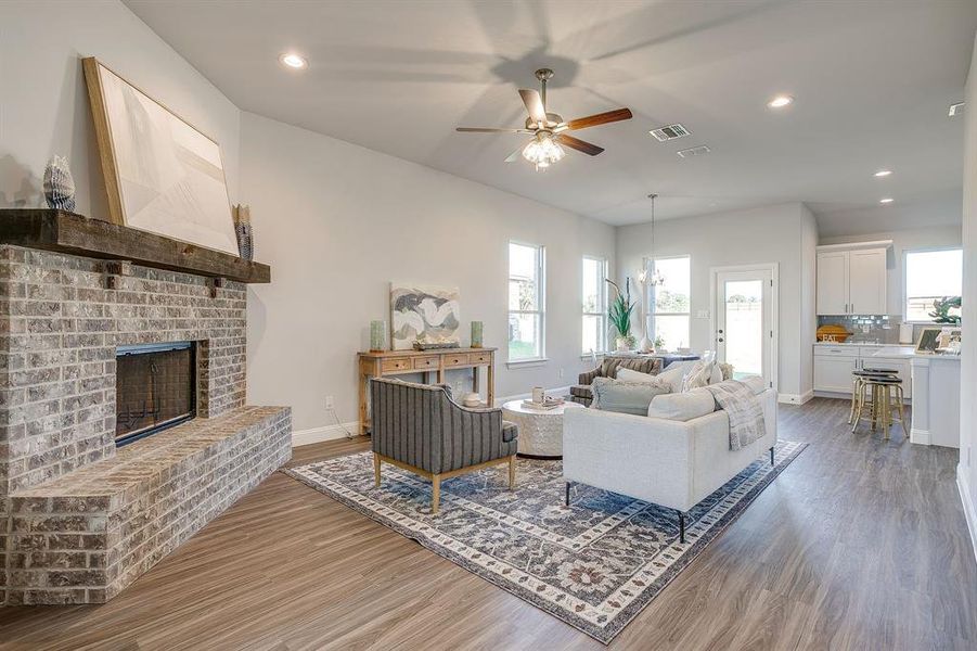 Living area featuring recessed lighting, light wood-type flooring, a fireplace, and ceiling fan