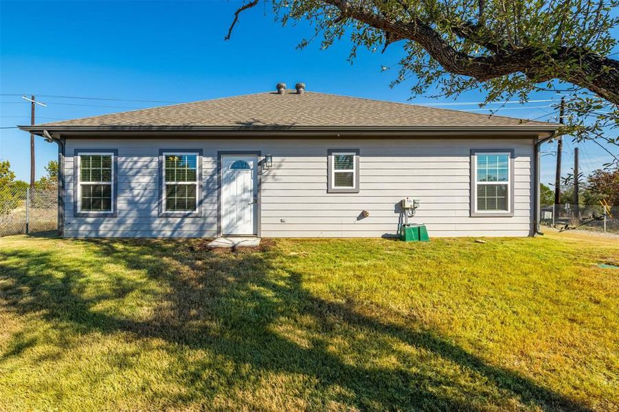 Back of house with a lawn