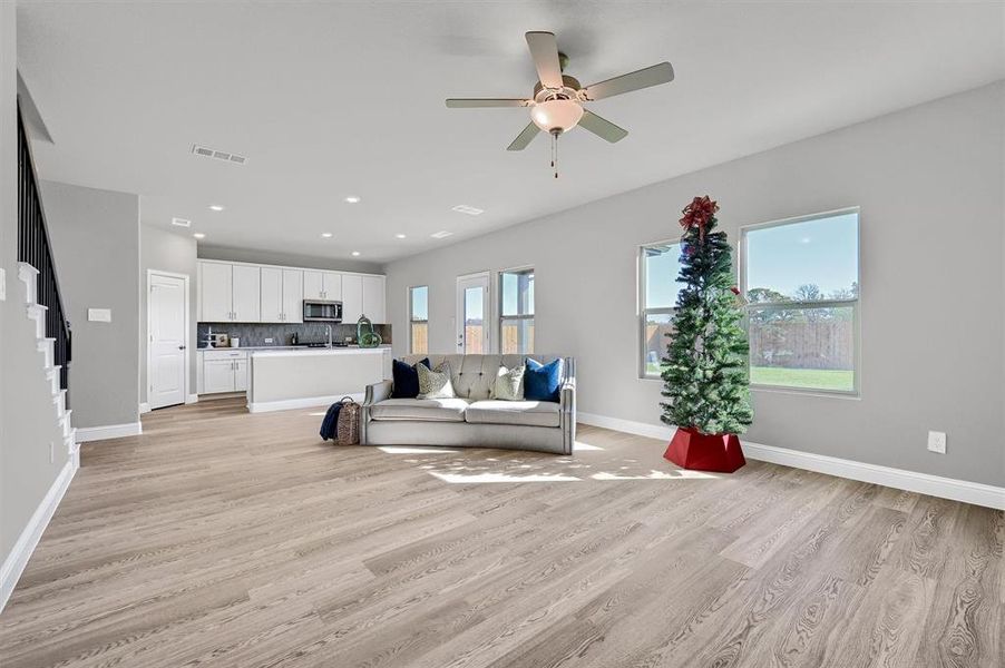 Unfurnished living room featuring light wood-type flooring and ceiling fan