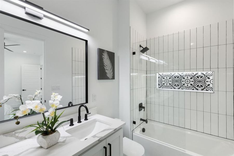 Full bathroom with ceiling fan, vanity, toilet, and tiled shower / bath