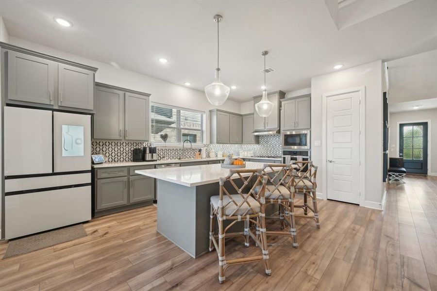 Kitchen featuring pendant lighting, a center island, light wood-type flooring, and appliances with stainless steel finishes