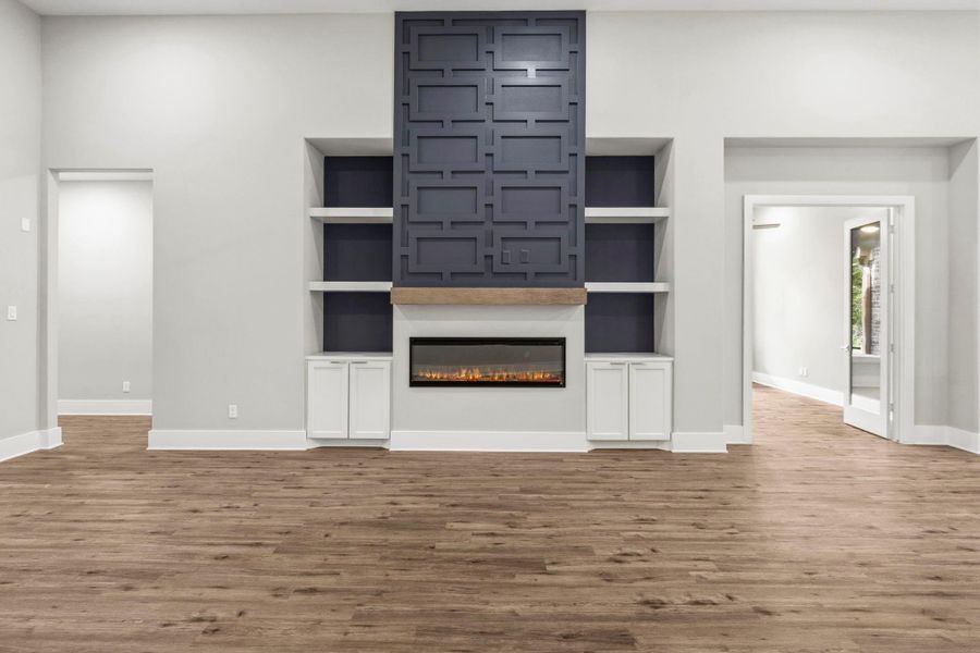 The custom fireplace wall commands attention with architectural detailing, built-in shelving, and a sleep linear fireplace.