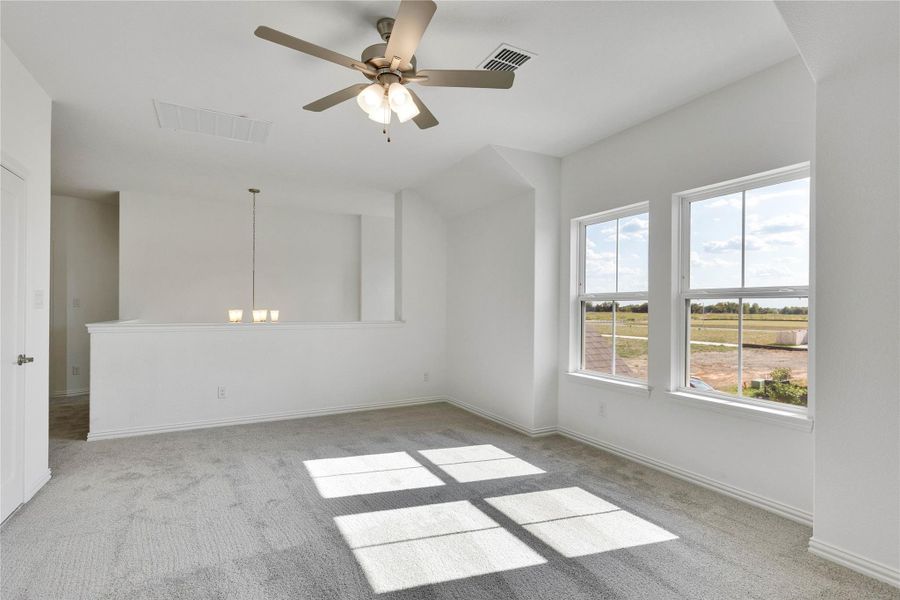 Unfurnished room with light colored carpet, a chandelier, and ceiling fan Unfurnished room with light colored carpet, a chandelier, and ceiling fan