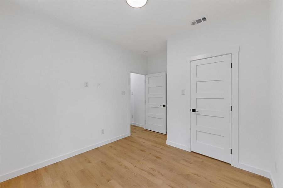 Unfurnished bedroom with baseboards and light wood-style floors Unfurnished bedroom with baseboards and light wood-style floors