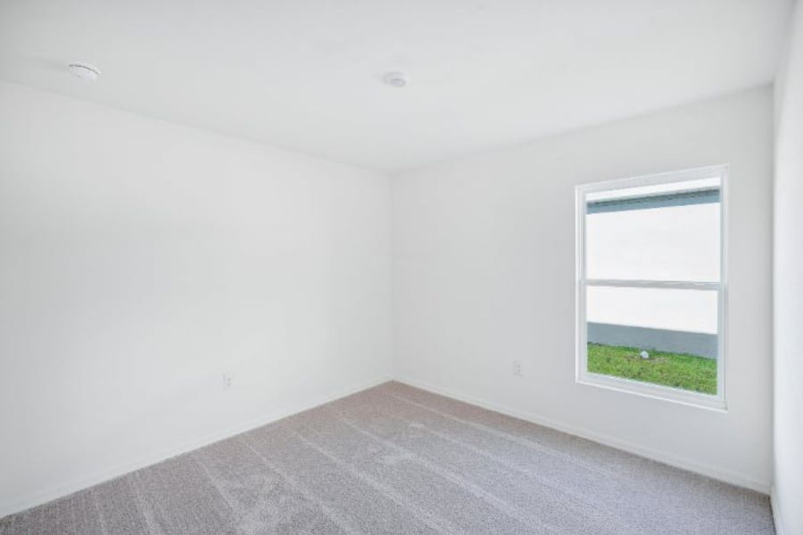A room with a window and a carpet.