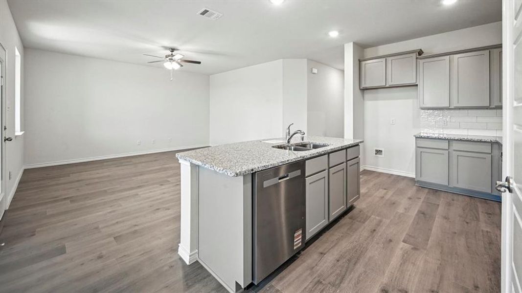 Open-concept living space featuring wood-finish flooring, a ceiling fan, and recessed lighting